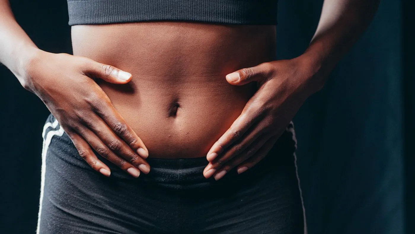 Woman holding her stomach comfortably, free of bloating