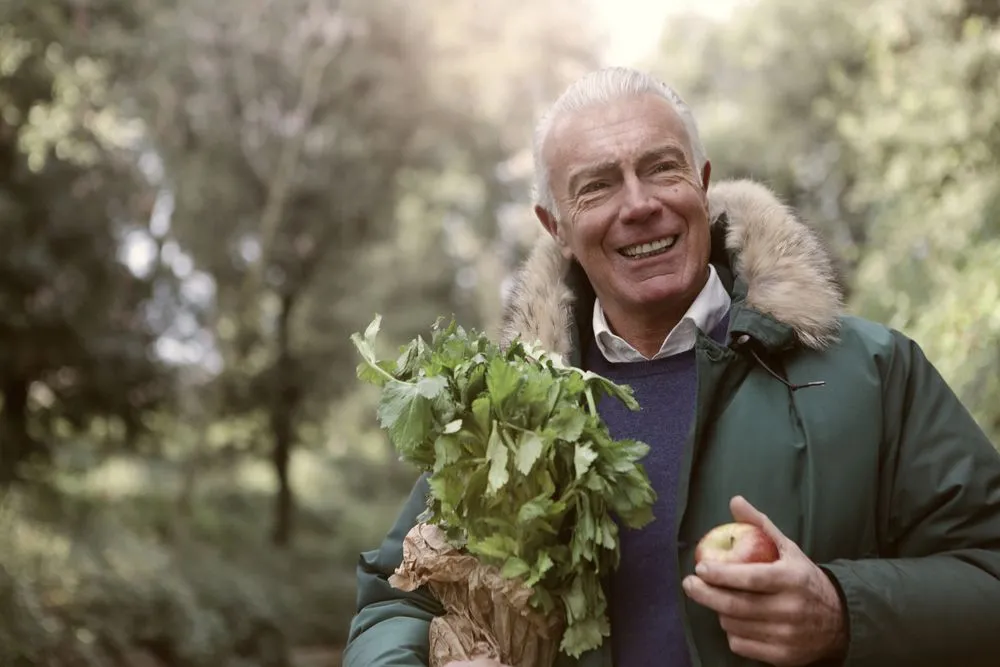 GutOptim Reviews 4 Healthy, happy man holding fresh produce outdoors
