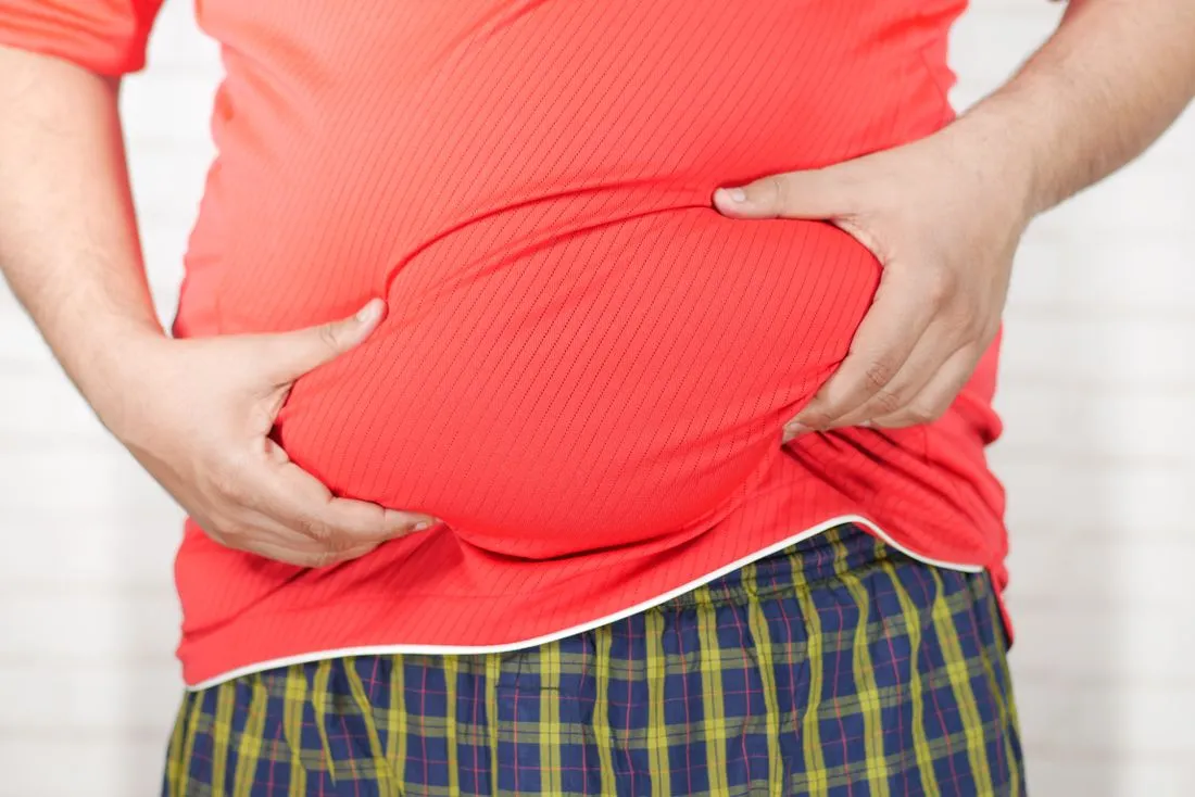 GutOptim Reviews 2 Man holding his bloated stomach in discomfort