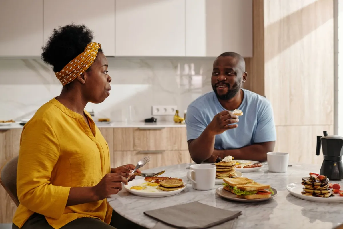 A couple enjoying a hearty breakfast together in a bright kitchen