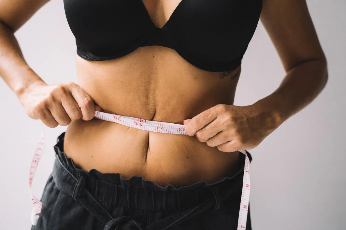 HoneyBurn Reviews: Does This Purple Weight-Loss Honey Work? 2 Woman measuring her waist, frustrated with stubborn weight