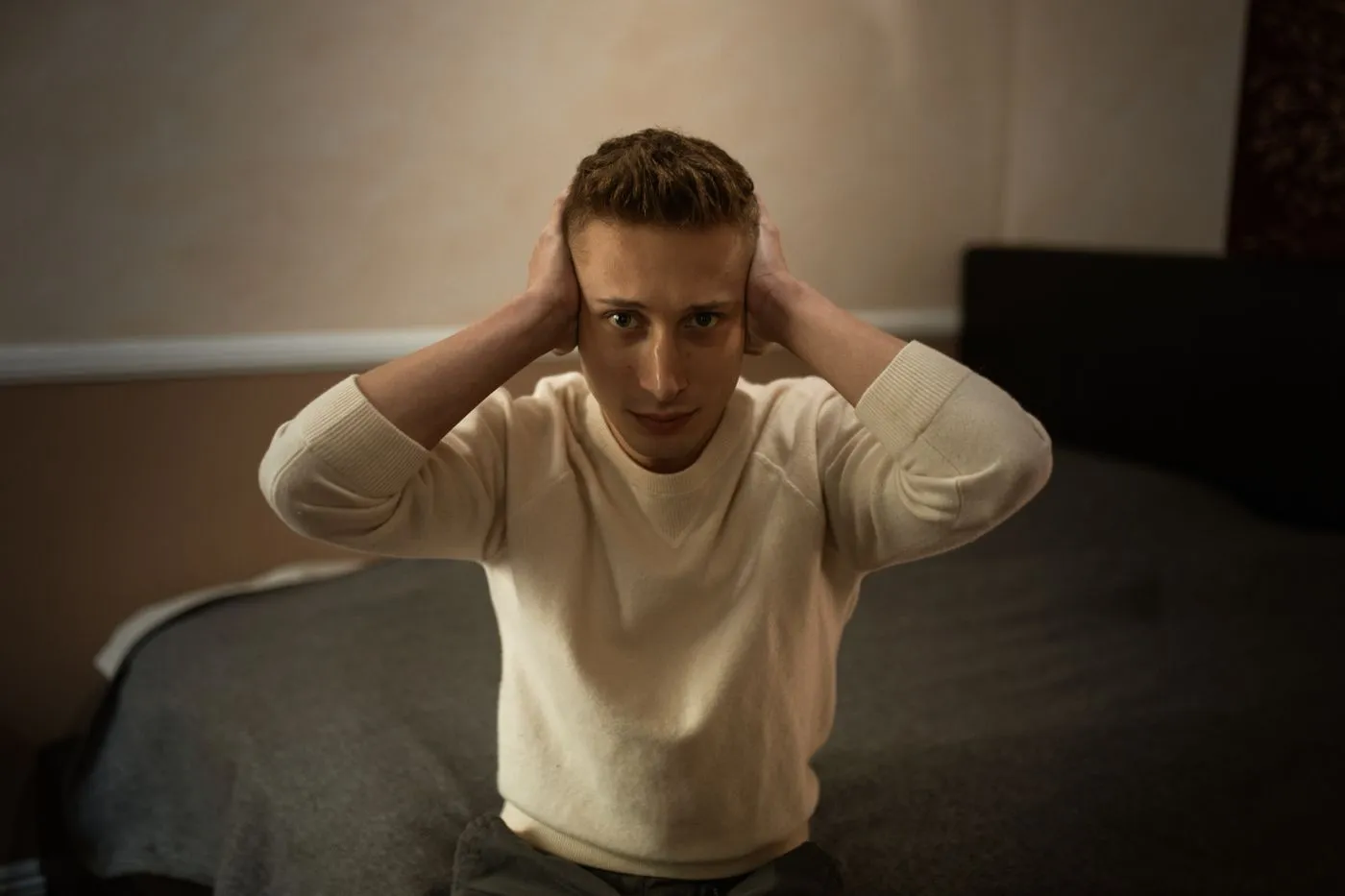 Quietum Plus Reviews: Does This Hearing Supplement Really Work? 2 Man sitting on the edge of his bed, distressed by ringing in his ears
